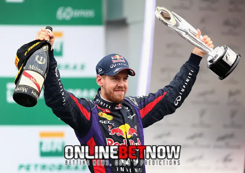 Sebastian-Vettel holding trophy and champagne after winning the race
